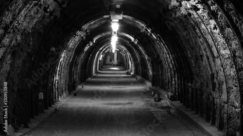 An old  illuminated  hollow underground tunnel in a closed coal mine.