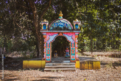 Gates of a small altar under a tree photo