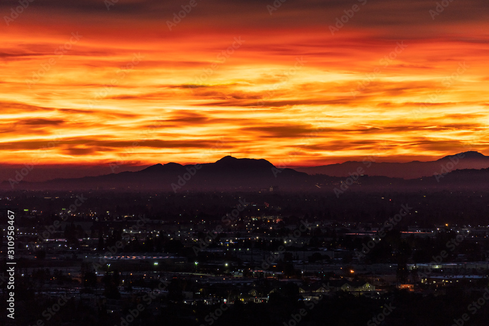 Fiery predawn view across the San Fernando Valley towards Griffith Park in the city of Los Angeles, California. Fiery predawn view across the San Fernando Valley towards Griffith Park in the city of Los Angeles, California.