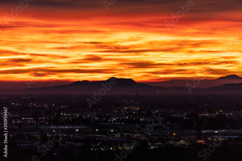Fiery predawn view across the San Fernando Valley towards Griffith Park in the city of Los Angeles, California. 