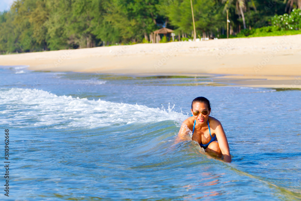 Woman with bikini blue play blue water at beach