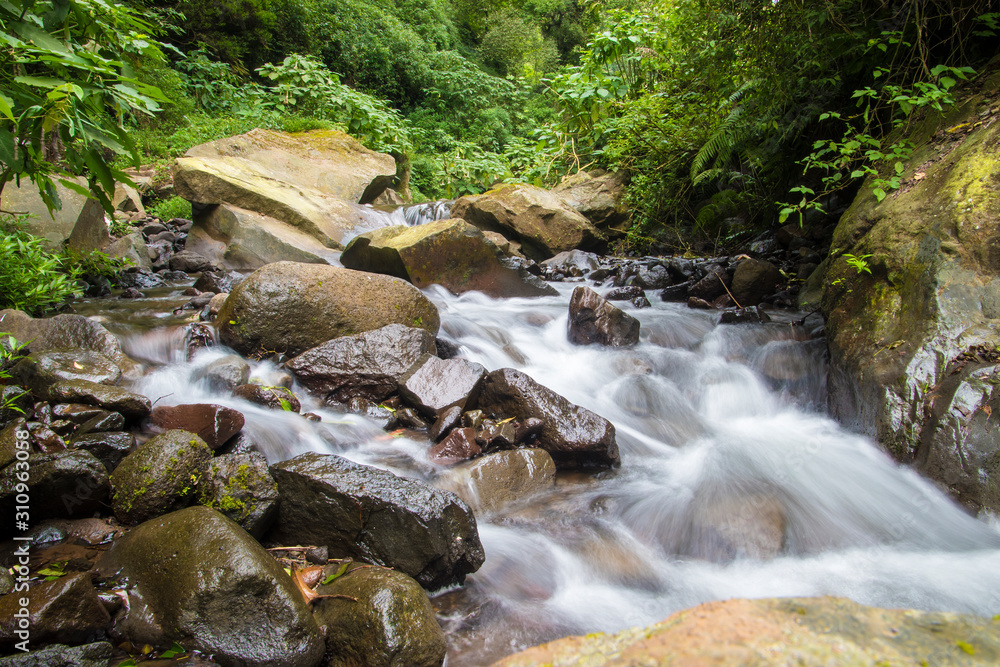 Obraz premium rocky river rafting area small waterfall in the forest in indonesia