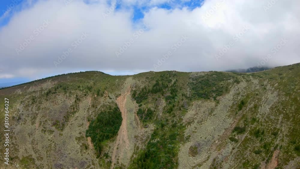 Aerial view of a steep mountain slope. Drone flies forward Aerial view of a steep mountain slope. Drone flies forward
