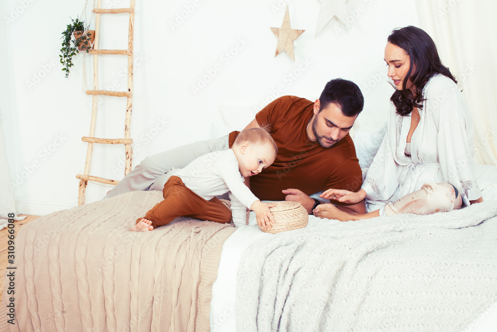 young happy family together having fun in bed, lifestyle people concept young happy family together having fun in bed, lifestyle people concept