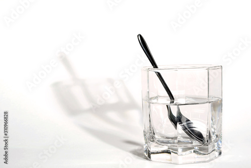 steel spoon in a glass with clear water
