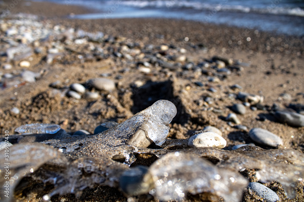 Ice shapes on the beach from rocks and pebbles in the winter Ice shapes on the beach from rocks and pebbles in the winter