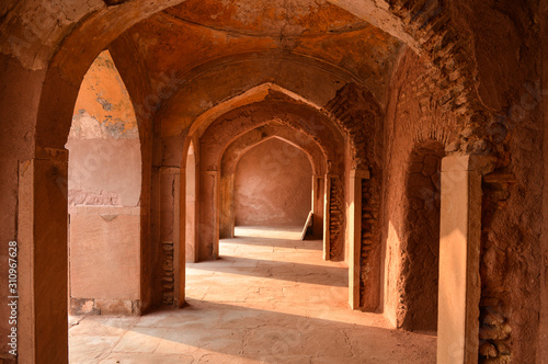 A mesmerizing view with sun rays create dramatic light and shadow of inside the hall of safdarjung tomb memorial from the main gate,entrance at winter morning.