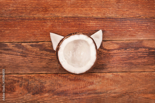 Coconut pieces on old wooden background. Top view. Cat face shape.