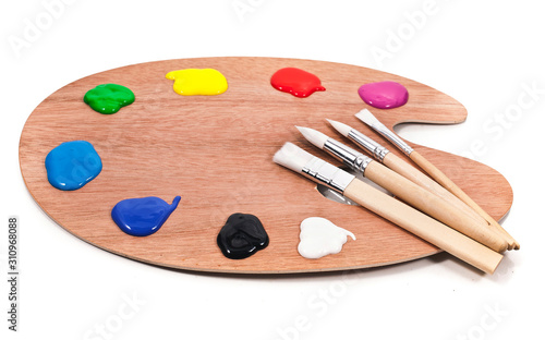Palette with paints and brushes isolated on a white background.