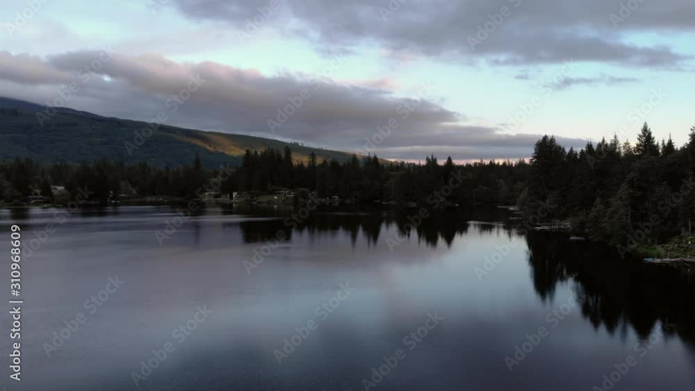 Drone dolly left and rise over northwest lake at sunset Drone dolly left and rise over northwest lake at sunset