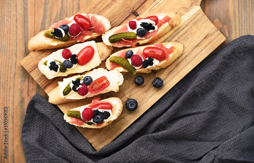 A lot of open-faced sandwich with berries  on wooden broad (German name is Belegtes Brot)