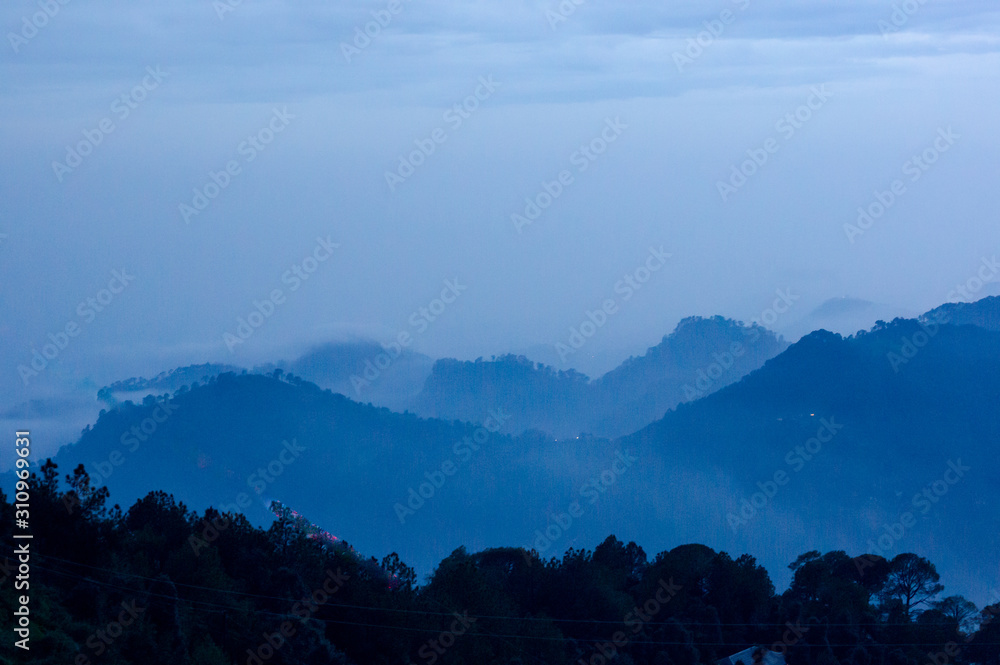 dusk shot of hills covered with fog and clouds shot at McLeodganj dharamshala India