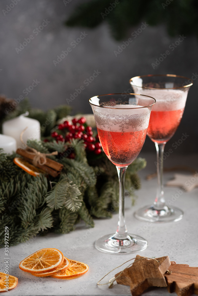 Rose champagne in a glass on the background of a Christmas wreath