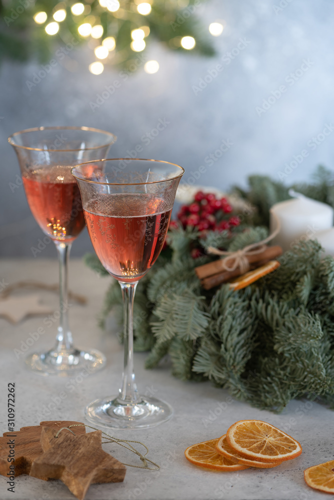Rose champagne in a glass on the background of a Christmas wreath