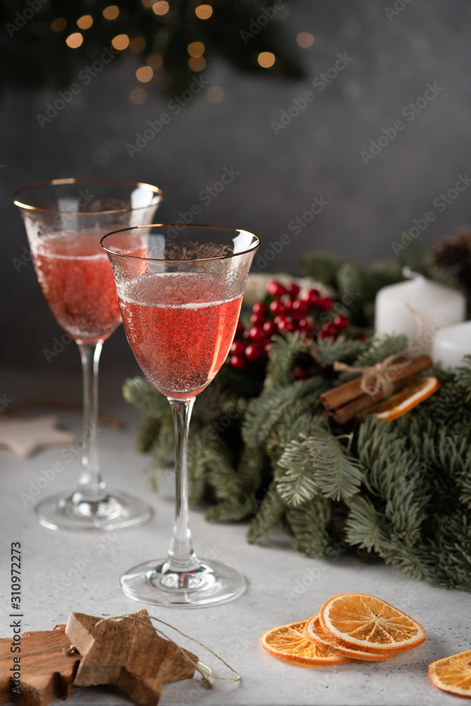 Rose champagne in a glass on the background of a Christmas wreath