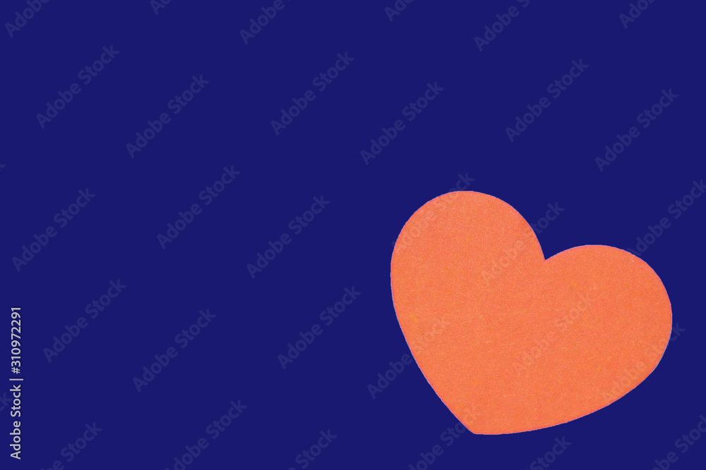 Bright orange heart isolated on a trendy bue background close-up. Top view, copy space. Valentine's Day greeting card Bright orange heart isolated on a trendy bue background close-up. Top view, copy space. Valentine's Day greeting card