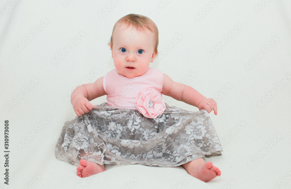 Fototapeta premium Close up Portrait of Cute Little 8 Month Old Baby Girl with Big Blue Eyes, in Pink and Silver Cute Dress, Happy and Healthy Baby