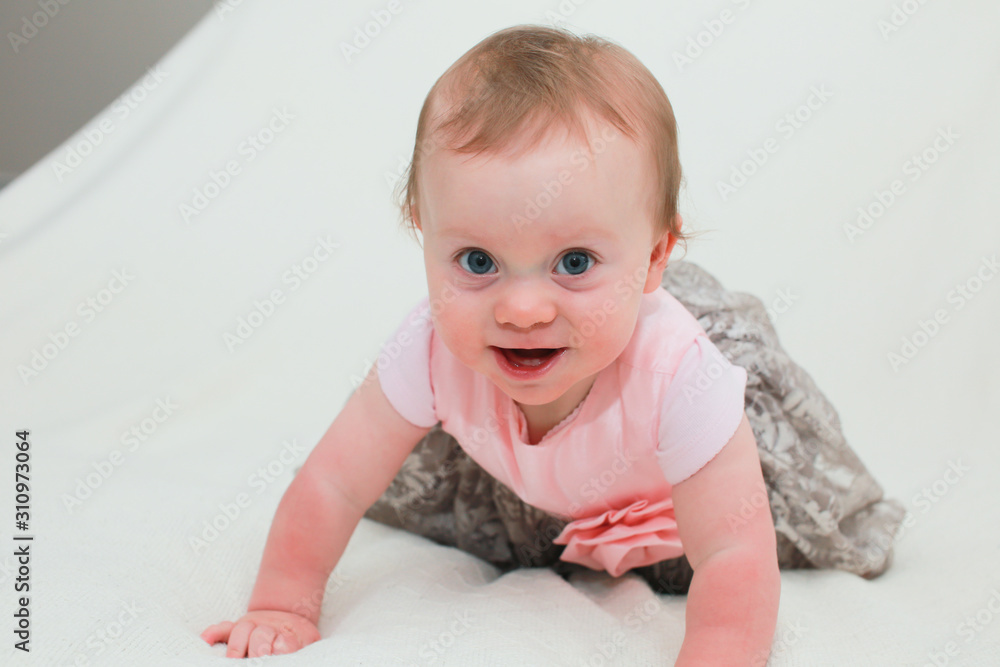 Fototapeta premium Close up Portrait of Cute Little 8 Month Old Baby Girl with Big Blue Eyes, in Pink and Silver Cute Dress, Happy and Healthy Baby