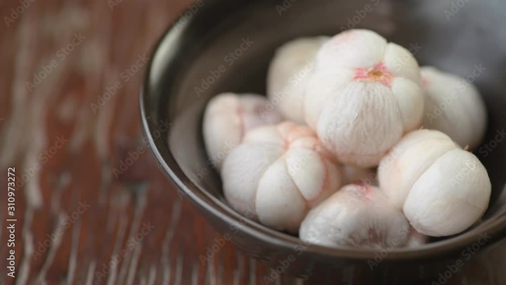 Putting down mangosteen flesh without skin in a small metal bowl. Putting down mangosteen flesh without skin in a small metal bowl.