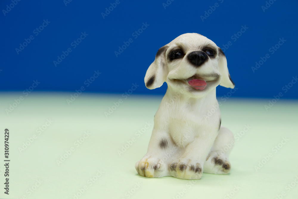 Stucco doll beagle puppy sit down  on blue screen. - obrazy, fototapety, plakaty 
