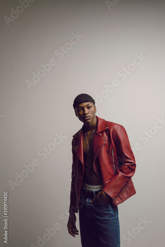 Studio portrait of young male model in red leather jacket photo