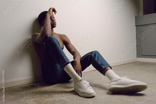 Studio portrait of young man wearing jeans and tennis shoes