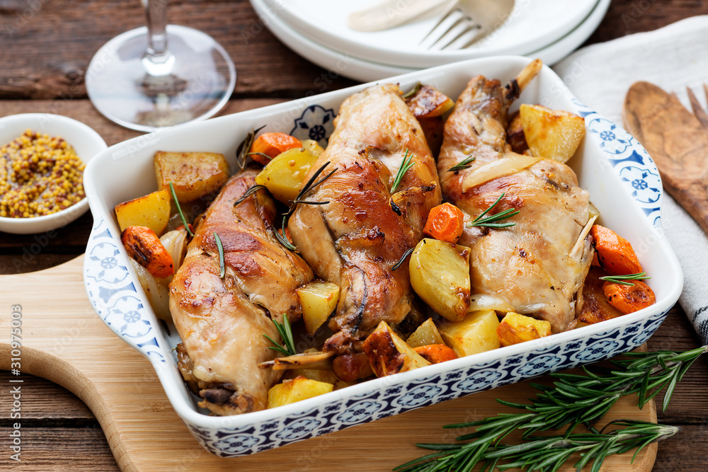 Stewed in white wine with spices rabbit legs with baked vegetables and rosemary. Stewed in white wine with spices rabbit legs with baked vegetables and rosemary.