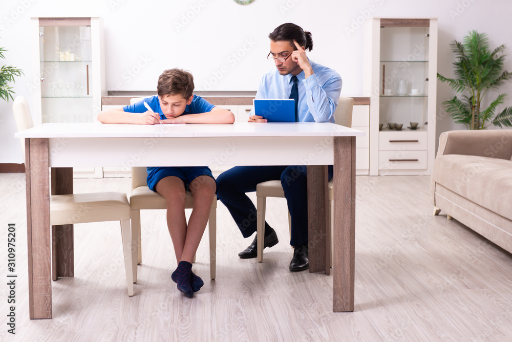 Busy father helping his son to prepare for exam Busy father helping his son to prepare for exam