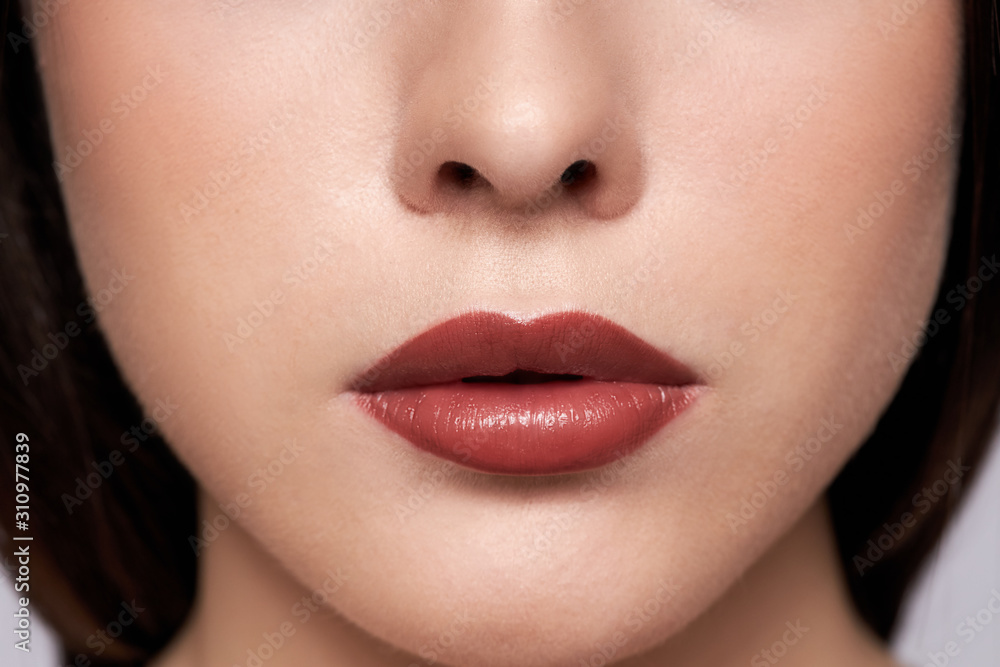 Obraz premium Perfect red lips makeup. Close up macro photo with a beautiful female mouth. Full lips full. Large detail of the face. Perfect clear skin, light fresh lip makeup. 