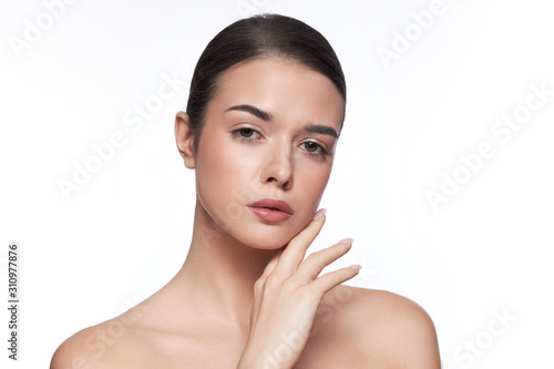 Portrait of a young girl with natural make-up on a white background. Beautiful Spa Model Girl with Perfect Fresh Clean Skin. Youth and Skin Care Concept