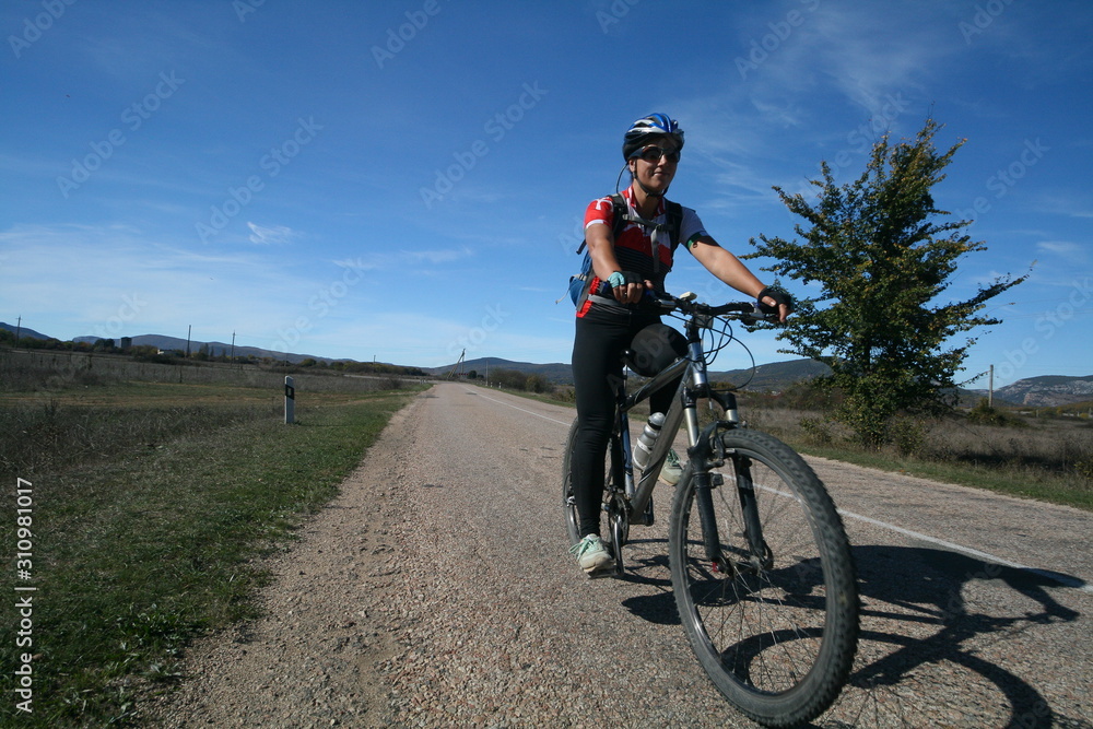 Fototapeta premium Young woman riding a bicycle, Crimea, Russia.