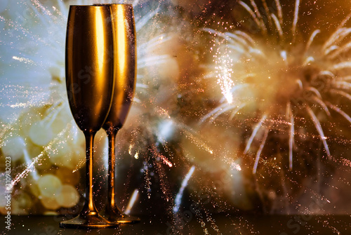 golden champagne glasses and fireworks at new year