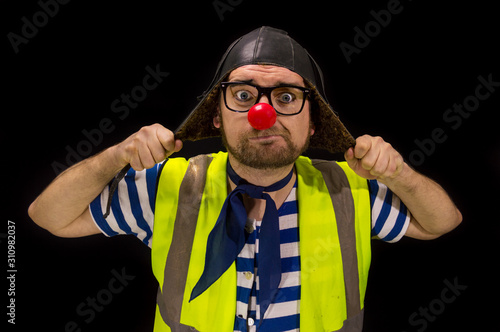 Clown in a pilot hat with red nose and glasses