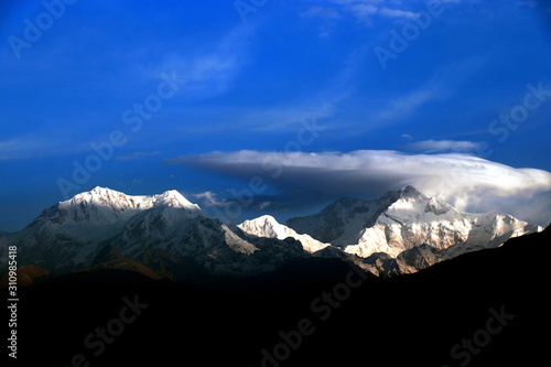 Kanchanjungha during golden hour, snow, peak, landscape, nature, Himalayan. Snowy mountains of Himalaya. A beautiful snowy mountain landscape under a blue cloudy sky..