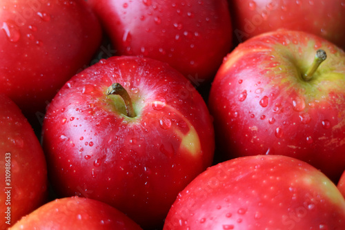 Closeup heap of ripe red apples with water droplets