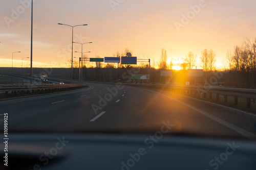 Sunrise on the road from the car window.