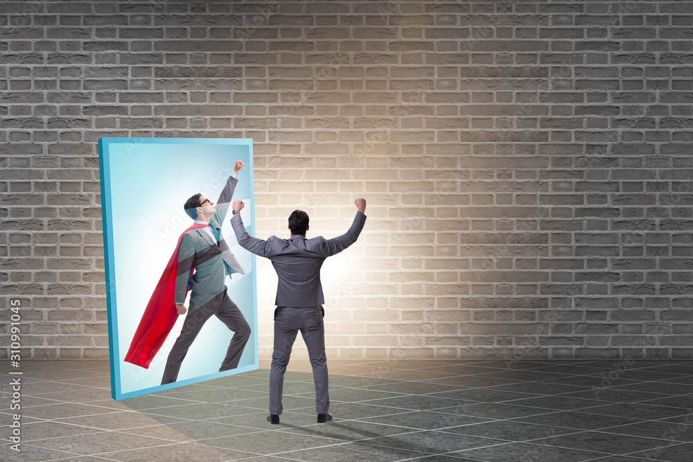 Businessman seeing himself in mirror as superhero Businessman seeing himself in mirror as superhero