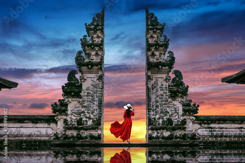 Young woman standing in temple gates at Lempuyang Luhur temple in Bali, Indonesia. photo
