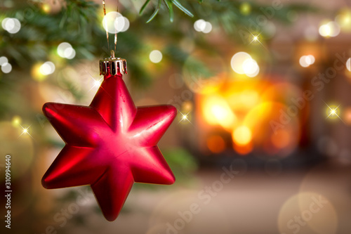 Red Christmas star against a stone fireplace. Bokeh holiday light background. photo