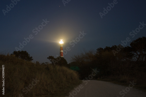 vuurtoren light house on ameland at night with lights and stars in the sky photo