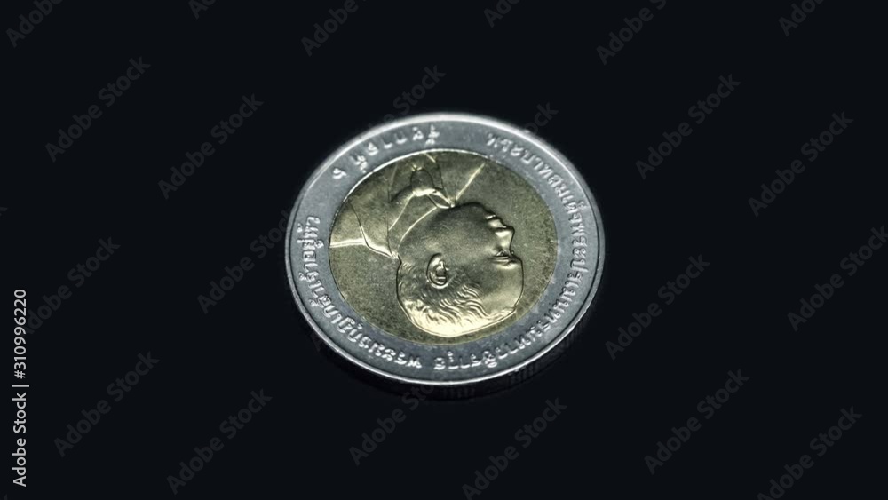 Commemorative coin of Thailand (baht) rotates on a black background. Macro. Closeup Commemorative coin of Thailand (baht) rotates on a black background. Macro. Closeup