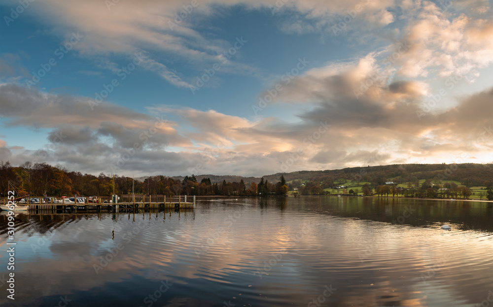 Stuning Autumn Fall sunrise landscape over Coniston Water with mist and wispy clouds