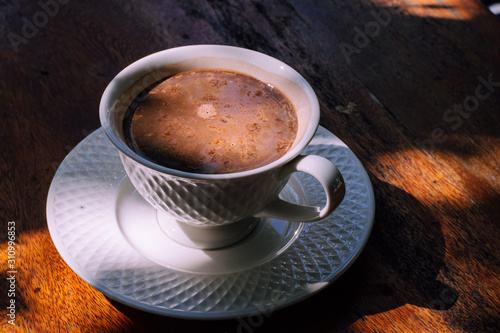 Cup of delicious hot cocoa on brown background, closeup