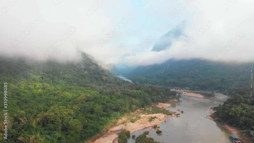 Aerial panoramic Nam Ou River drone flying over morning fog mist and clouds, Nong Khiaw Muang Ngoi Laos, dramatic landscape scenic pinnacle cliff, famous travel destination in South East Asia Aerial panoramic Nam Ou River drone flying over morning fog mist and clouds, Nong Khiaw Muang Ngoi Laos, dramatic landscape scenic pinnacle cliff, famous travel destination in South East Asia