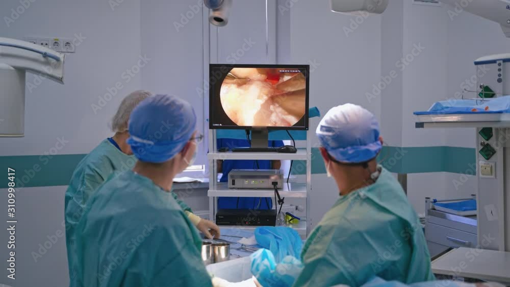 Endoscopic surgery on the monitor. Surgeons perform an operation and look at the screen of a monitor in the operating room. Modern technologies in medicine. Endoscopic surgery on the monitor. Surgeons perform an operation and look at the screen of a monitor in the operating room. Modern technologies in medicine.