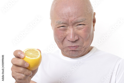 Fotografía 酸っぱいレモンを食べるシニア