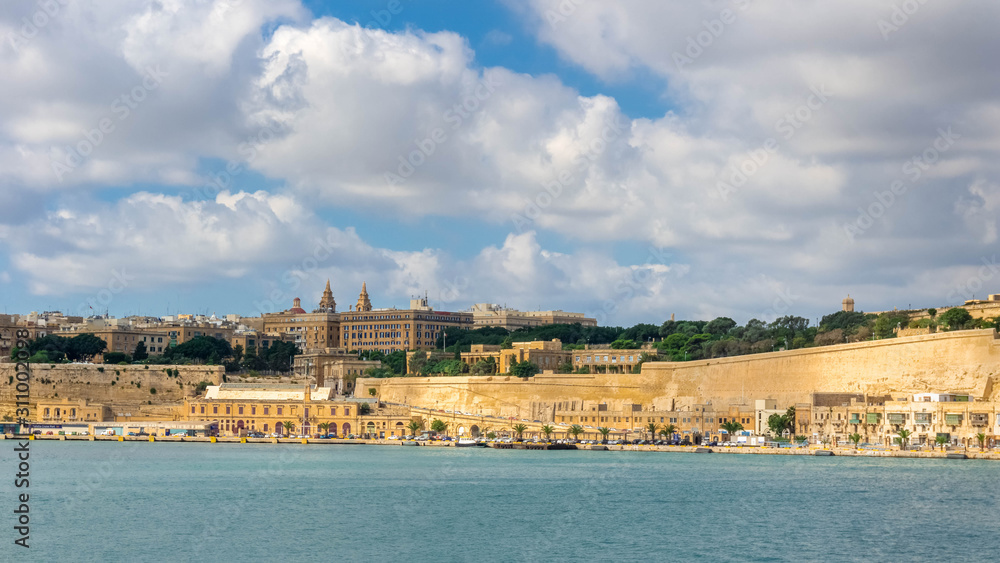 Panoramic coastline view of Valletta city with sea and cloudy sky