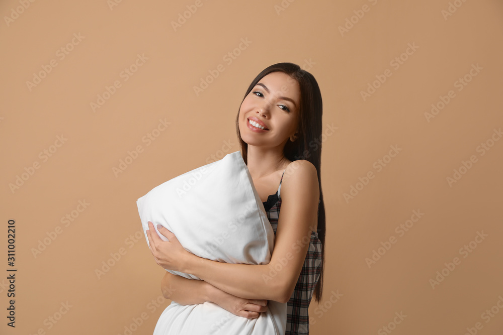 Beautiful Asian woman with pillow on beige background. Bedtime Beautiful Asian woman with pillow on beige background. Bedtime