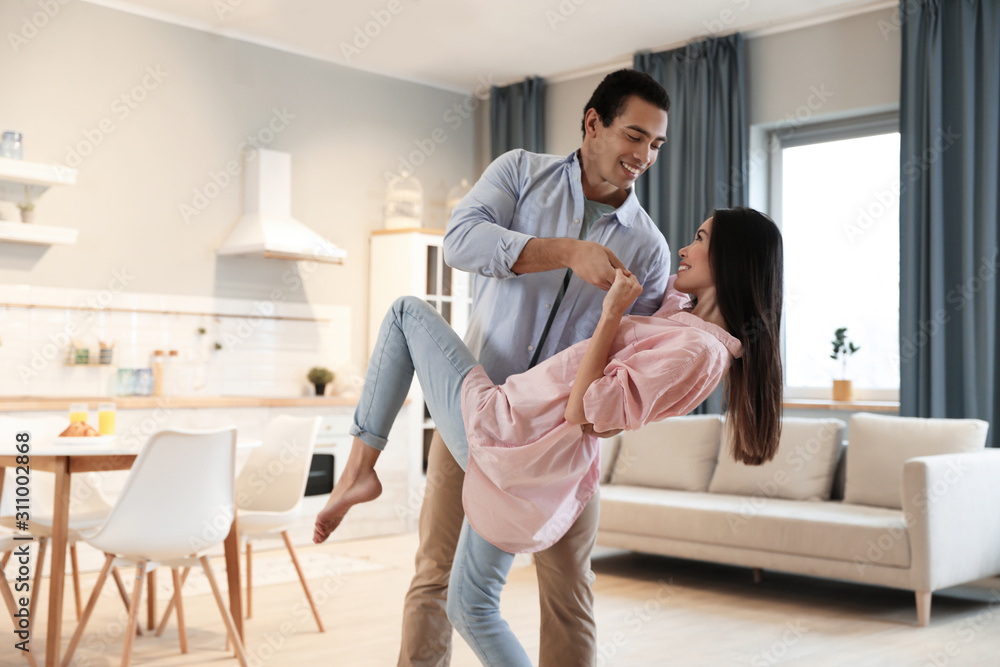 Lovely young interracial couple dancing at home Lovely young interracial couple dancing at home