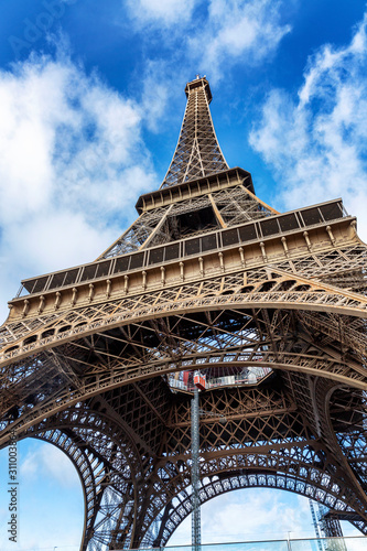 Eiffel Tower on a background of bright blue sky. Vertical. View from below.